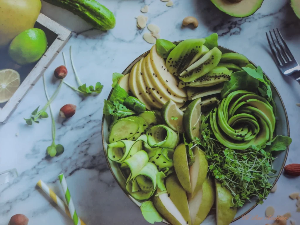 Bol sain et coloré composé d'avocat, de concombre, de kiwi, de poire et de jeunes pousses.