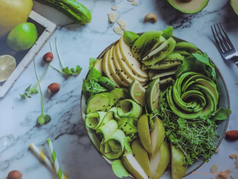 Bol sain et coloré composé d'avocat, de concombre, de kiwi, de poire et de jeunes pousses.